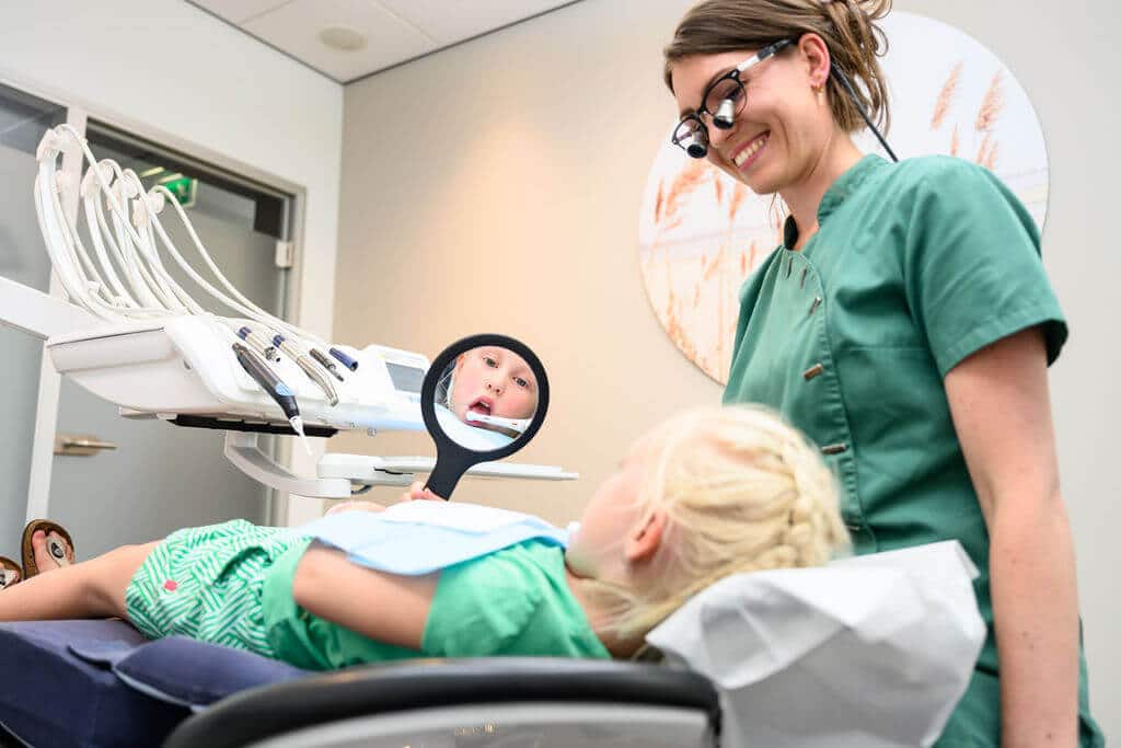 Mondhygiënist legt rustig de mondgezondheid uit tijdens preventieve behandeling bij Kies & Co in IJsselstein